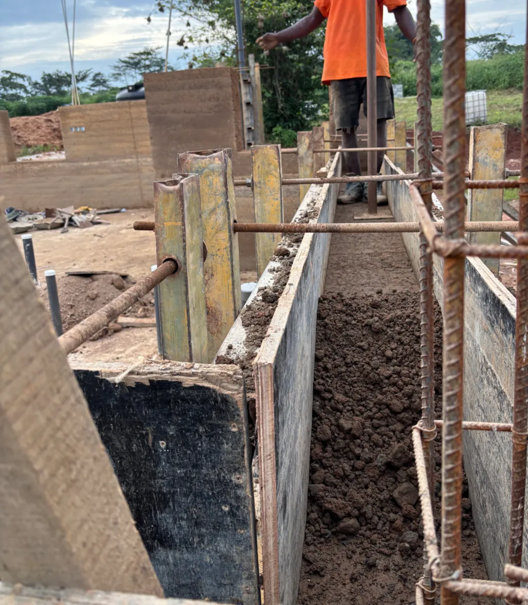 Rammed earth construction in progress with formwork
