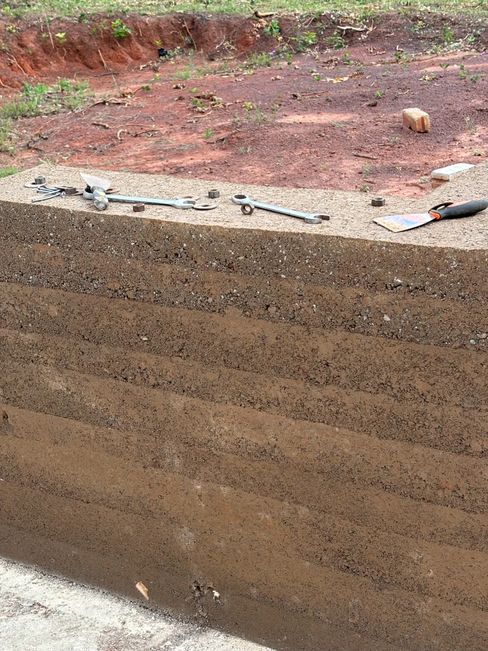 Fresh rammed earth lifts with hand tools resting on top